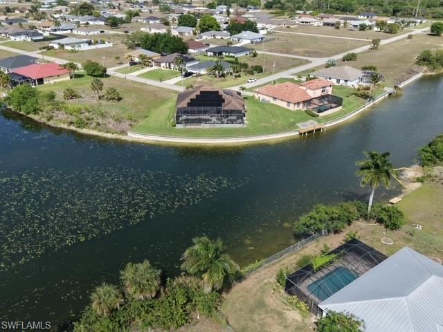 Aerial perspective of suburban area featuring a nearby body of water