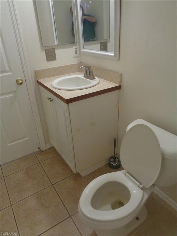 Guest bathroom featuring vanity, toilet and light tile patterned flooring