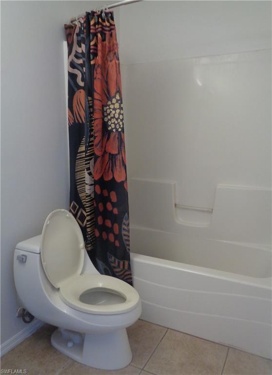 Master's bedroom's bathroom featuring   toilet and tub/shower and light patterned flooring