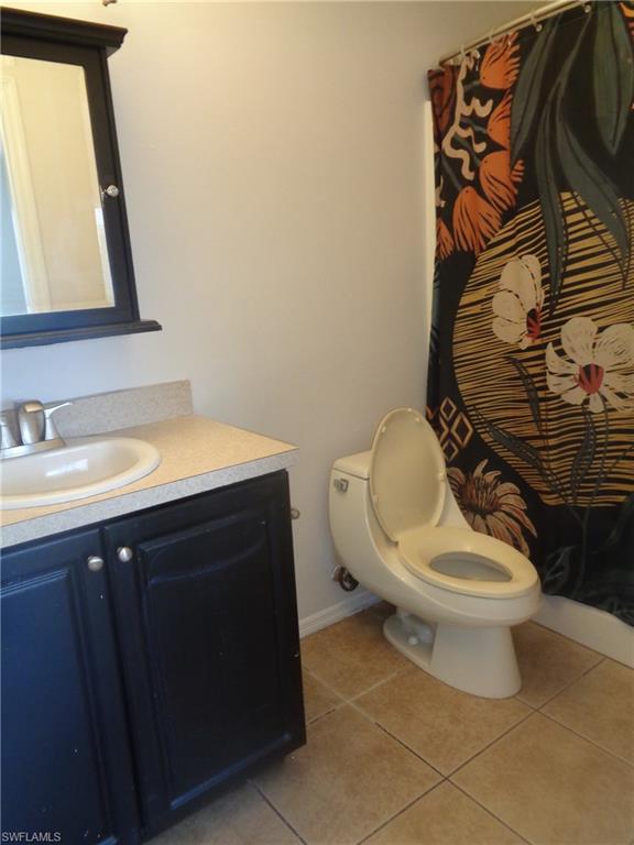 Master bedroom's bathroom featuring vanity, toilet and light tile patterned flooring