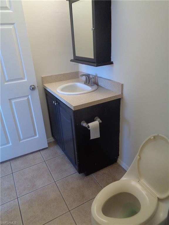 Master bedroom's bathroom featuring vanity, toilet and light tile patterned flooring