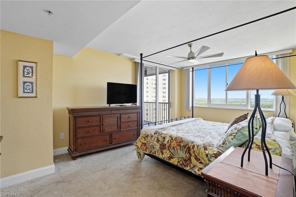 Bedroom featuring light carpet, a ceiling fan, and a textured wall - Virtually Edited Image