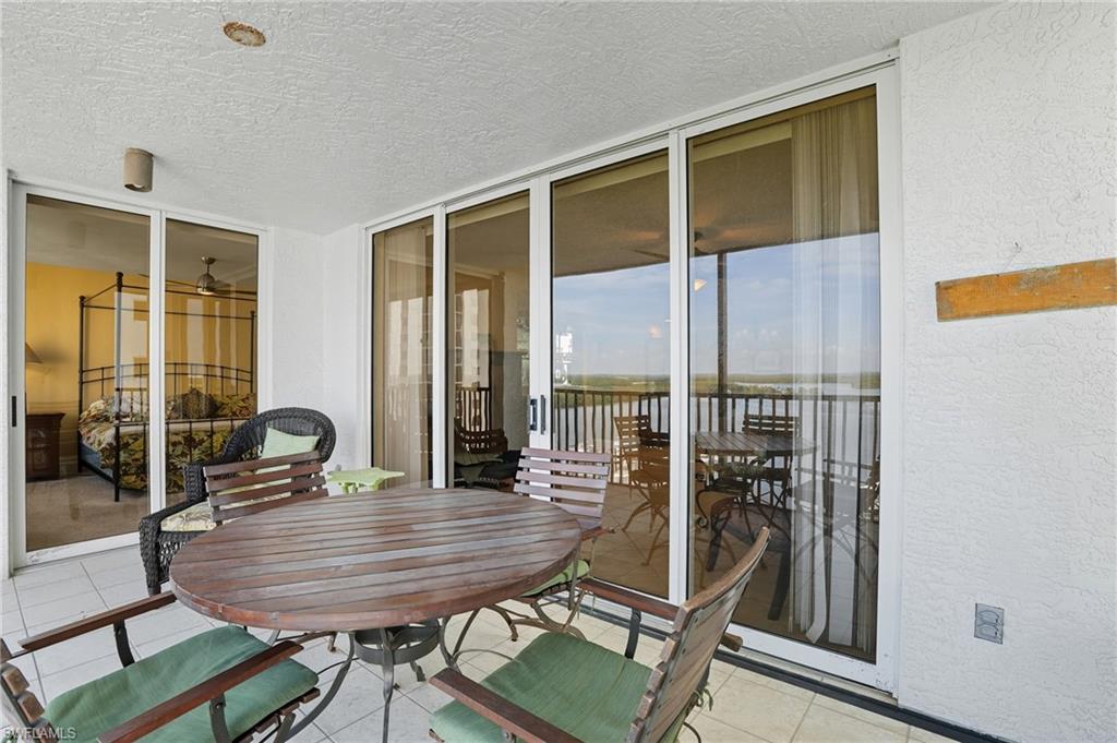 Sunroom with outdoor dining space, a water view, and a patio area - Virtually Edited Image