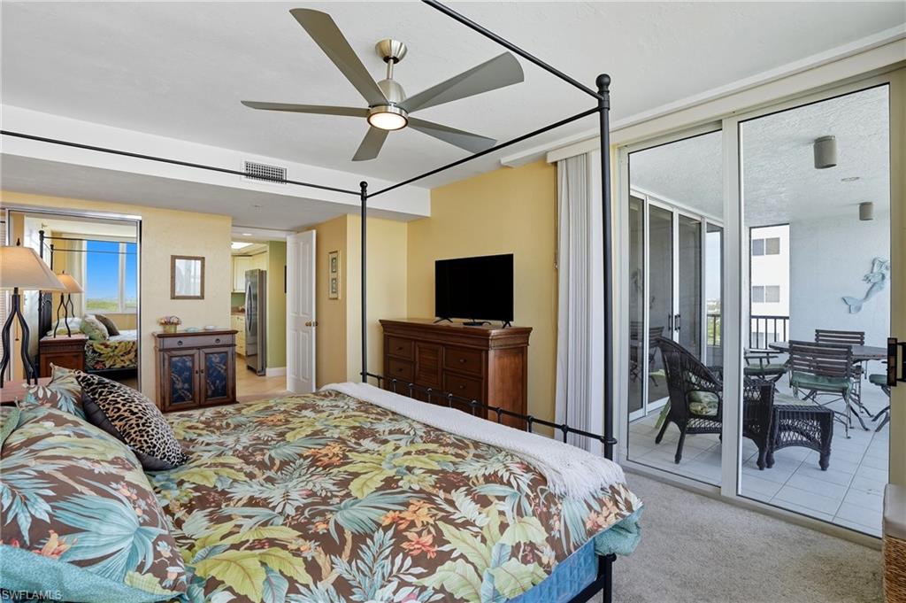 Bedroom with light colored carpet, ceiling fan, access to exterior, and freestanding refrigerator - Virtually Edited Image