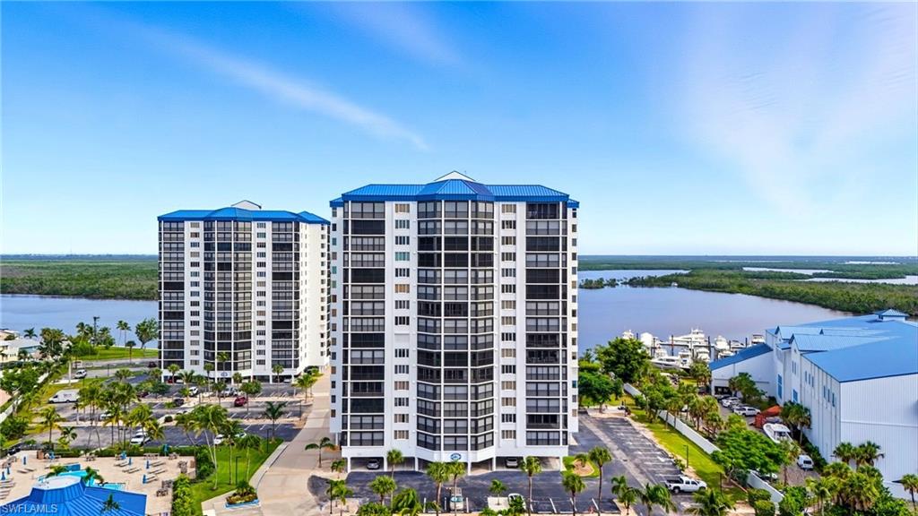 View of condo building / complex featuring a water view - Virtually Edited Image