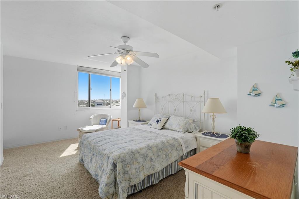 Carpeted bedroom with ceiling fan and baseboards - Virtually Edited Image