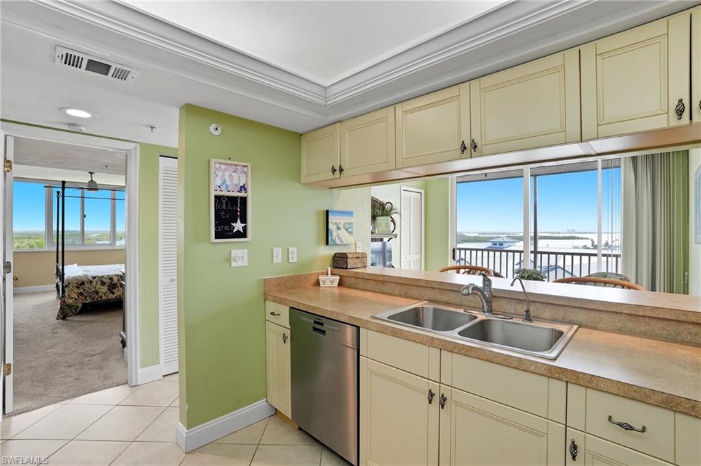 Kitchen with cream cabinetry, healthy amount of natural light, and stainless steel dishwasher - Virtually Edited Image
