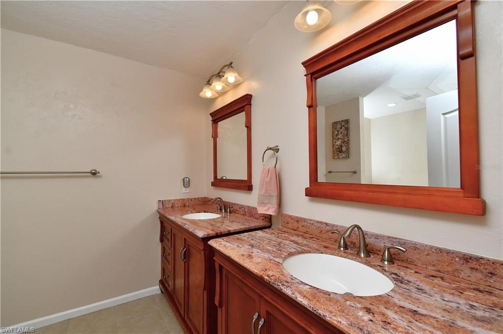Bathroom with two vanities and light tile patterned floors