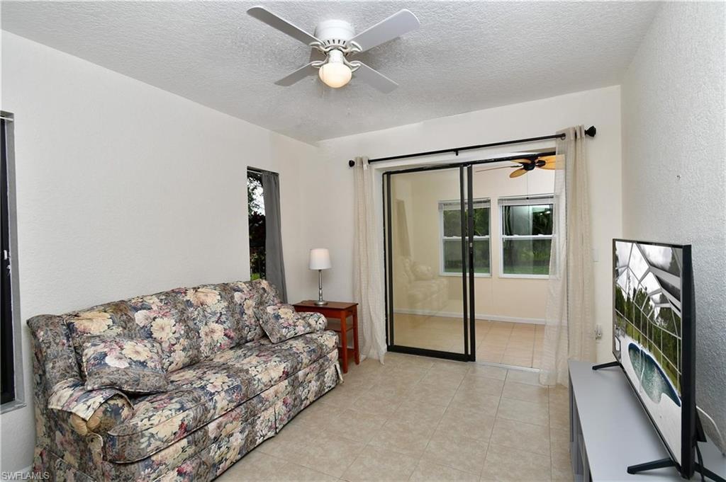 Bedroom 3 featuring a ceiling fan and sliding glass doors leading to enclosed lanai.