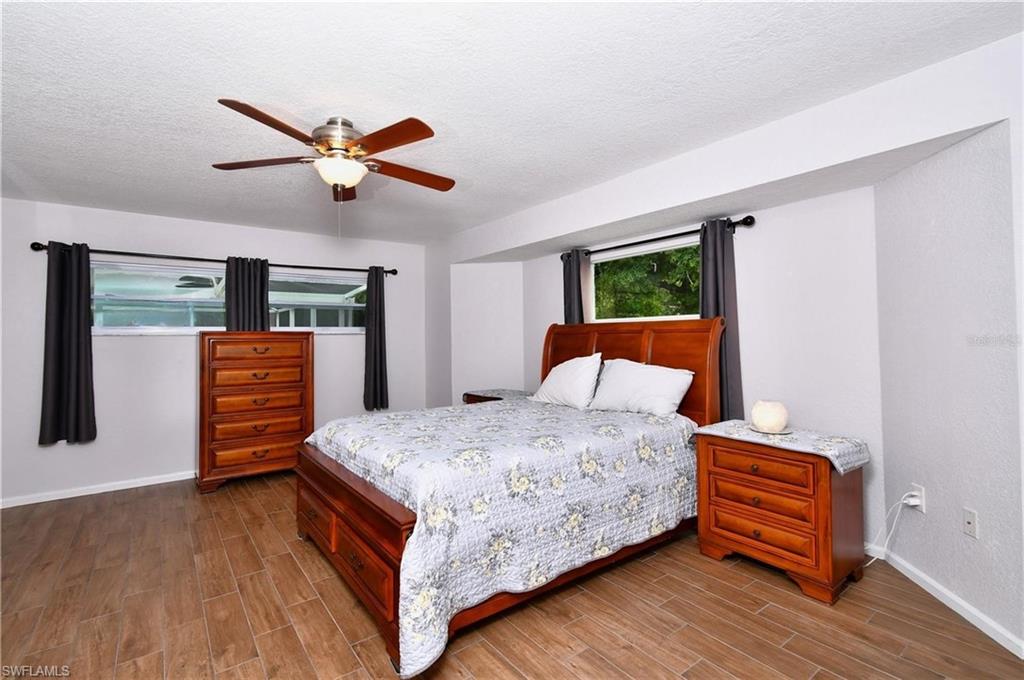 Bedroom featuring wood finish floors, a ceiling fan, and a textured ceiling