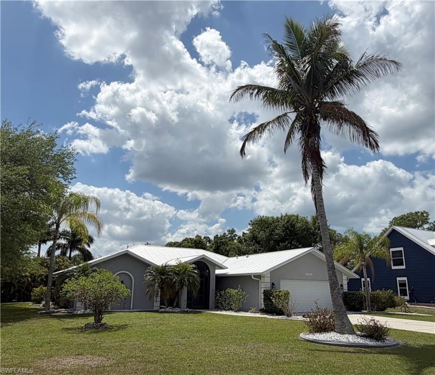 Ranch-style house featuring a front lawn, stucco siding, an attached garage, and concrete driveway