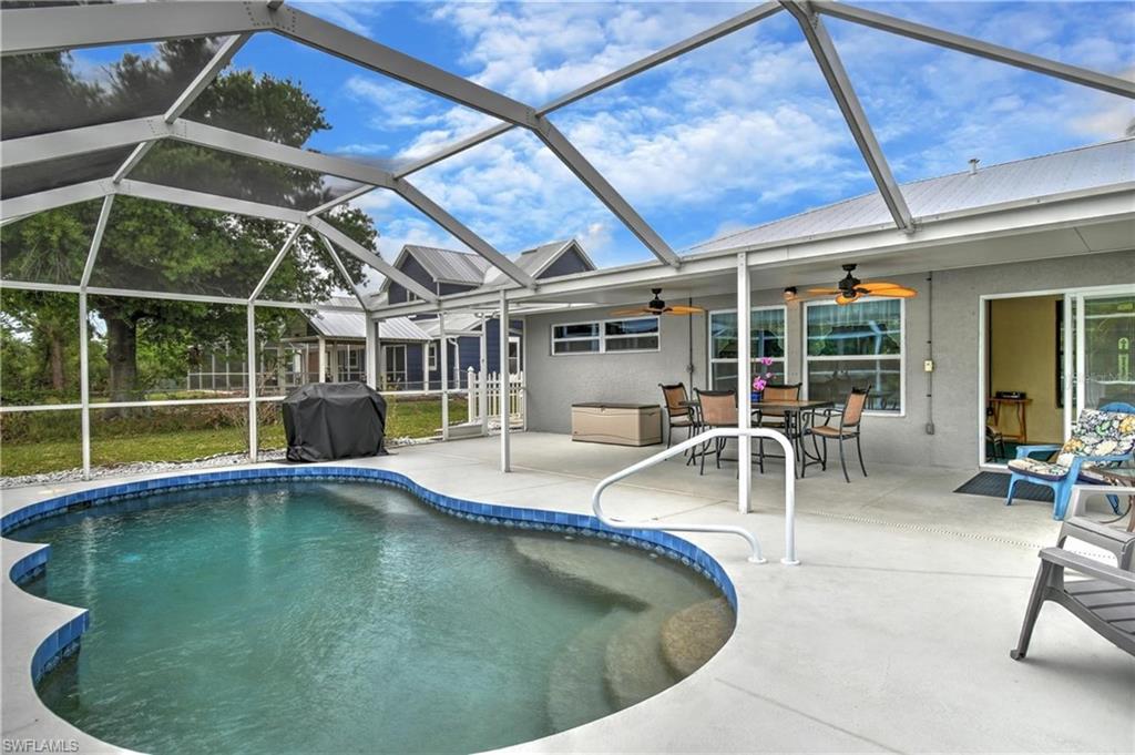 Outdoor pool with outdoor dining area, glass enclosure, a sunroom, and a patio