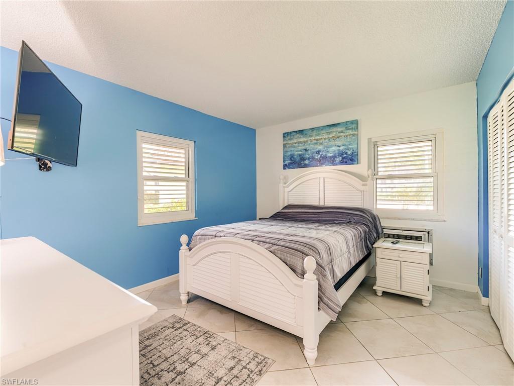 Bedroom with light tile patterned floors, a textured ceiling, and a closet