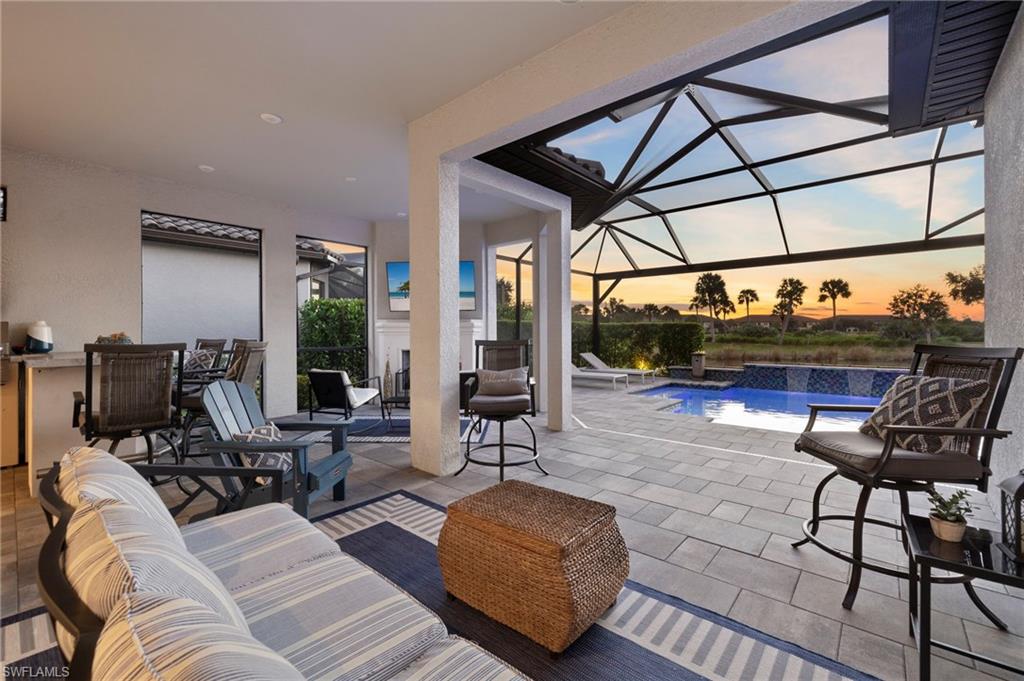 Patio terrace at dusk featuring pool water feature and a lanai