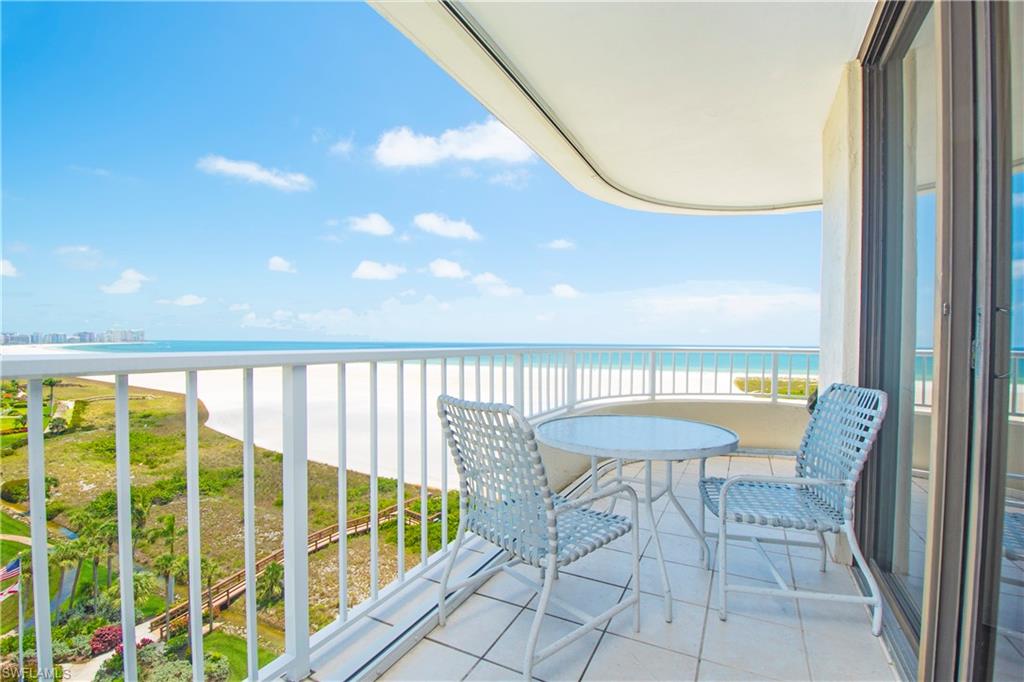 Balcony featuring view of water and beach