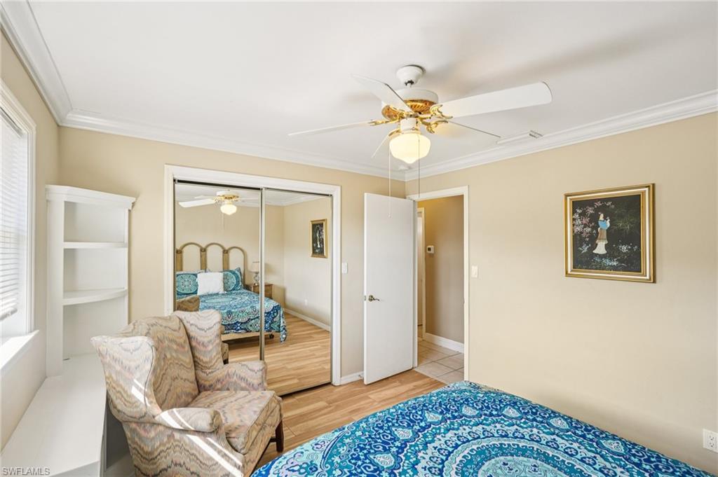 Bedroom with crown molding, a ceiling fan, light wood-style floors, and a closet