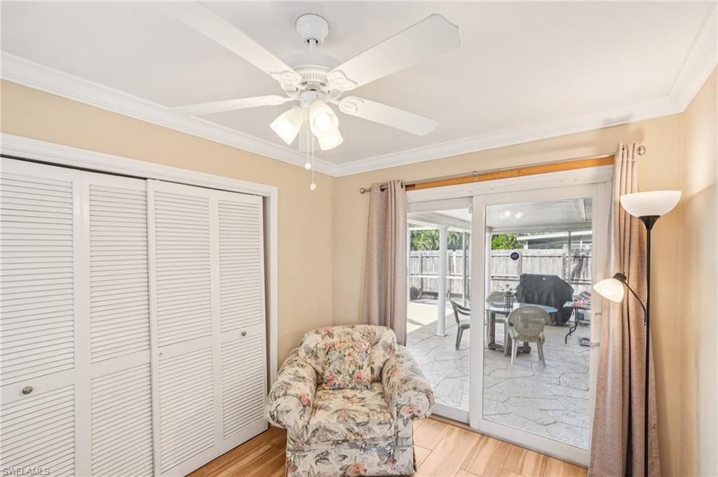 Living area with light wood-style flooring, crown molding, and a ceiling fan