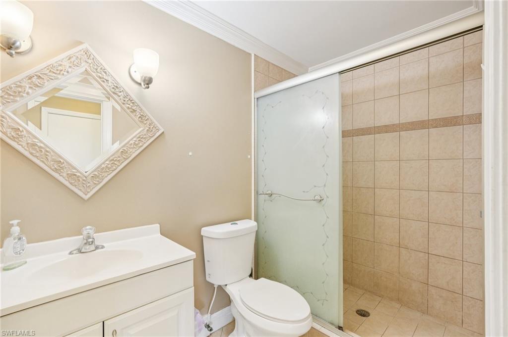 Full bath with vanity, a stall shower, and ornamental molding