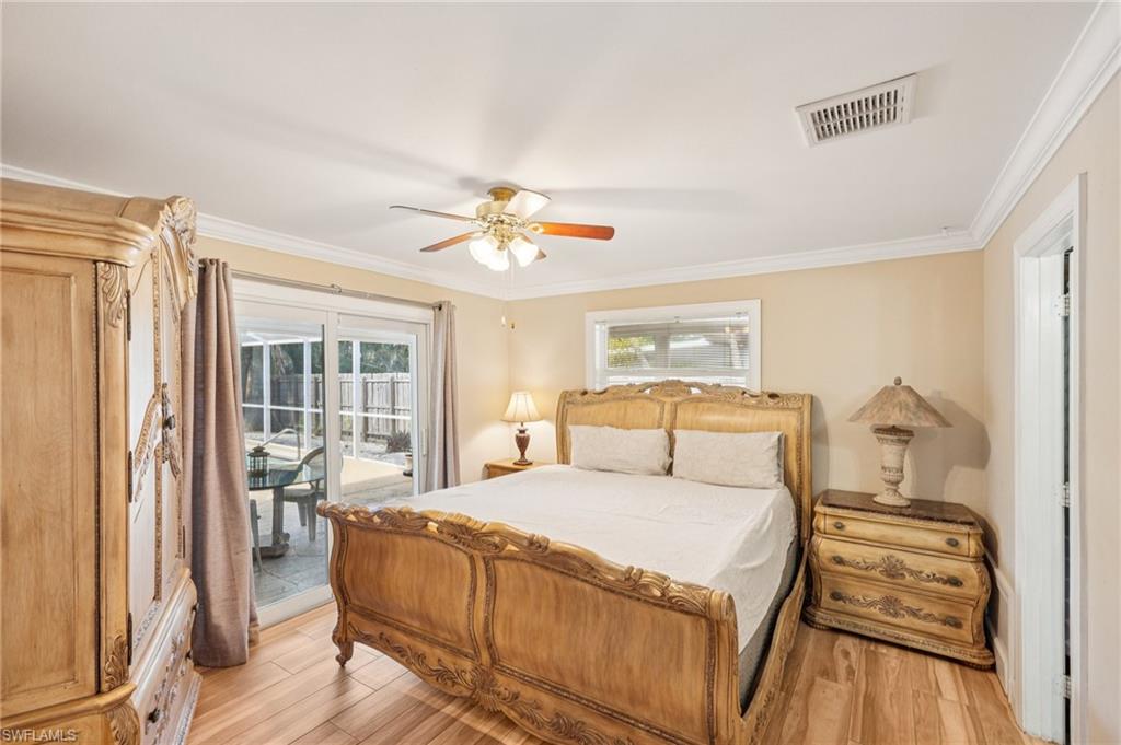 Bedroom with light wood-style flooring, multiple windows, crown molding, ceiling fan, and access to exterior