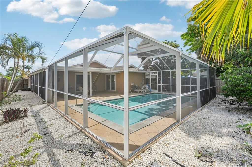 View of pool featuring a fenced backyard, a sunroom, a lanai, and patio surround