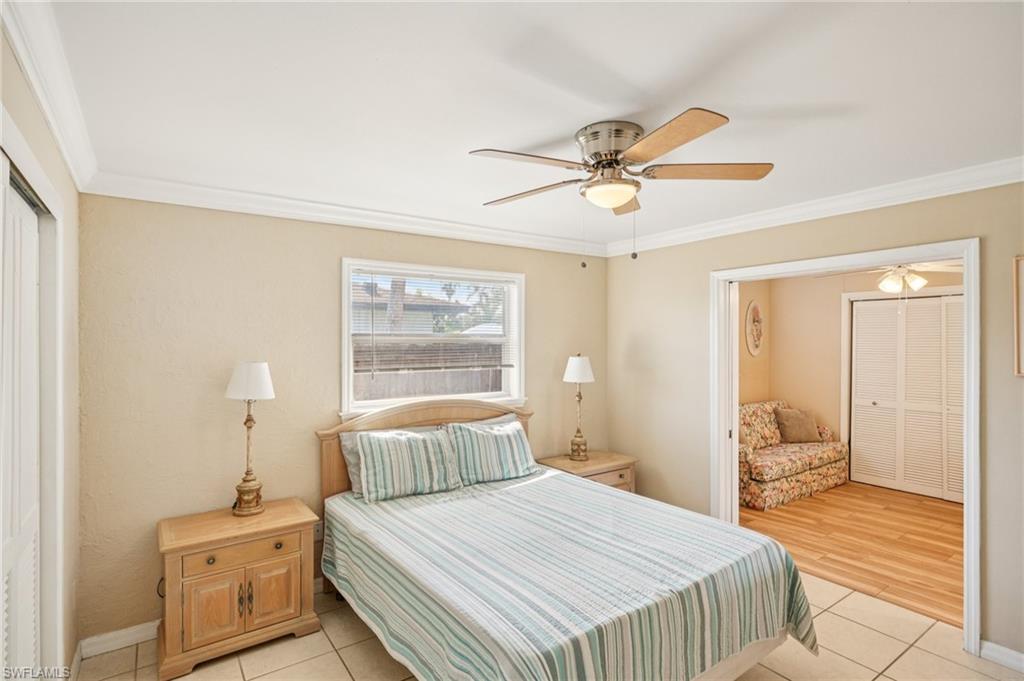 Bedroom featuring a closet, light tile patterned floors, ceiling fan, and ornamental molding