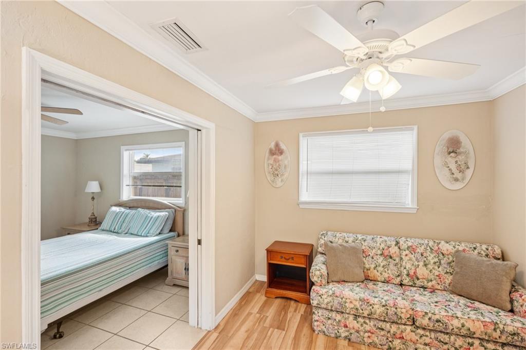Bedroom with a ceiling fan, crown molding, and light wood-type flooring