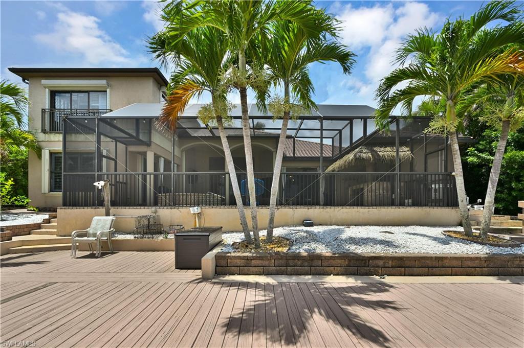 Expansive wood-finish deck with mature palm trees