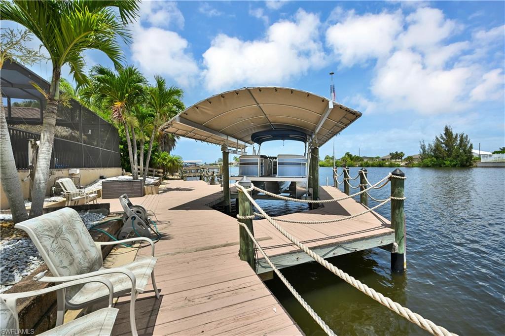 Waterfront dock with a covered boat lift, featuring robust pilings and rope accents