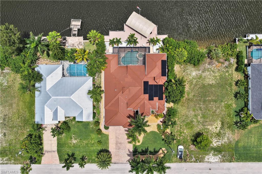Aerial perspective showcasing a waterfront property with a private boat dock and lift