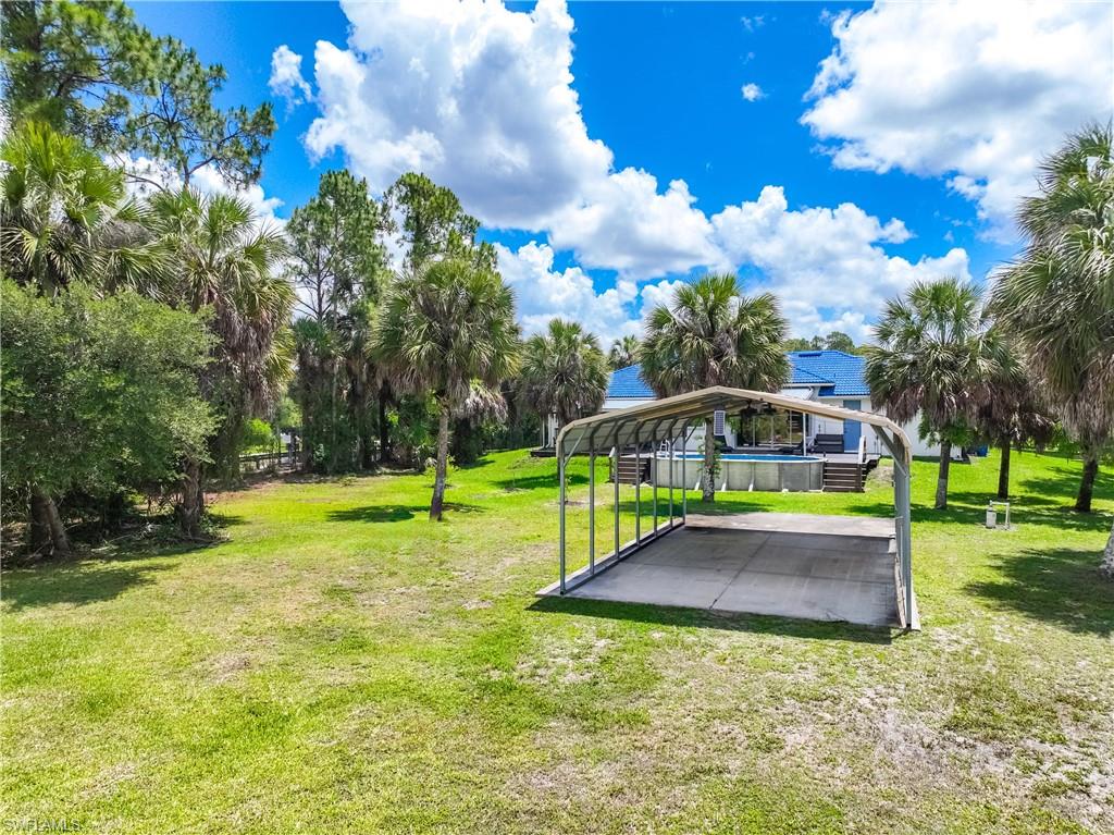 Covered parking structure offers additional storage or parking within the spacious backyard setting.