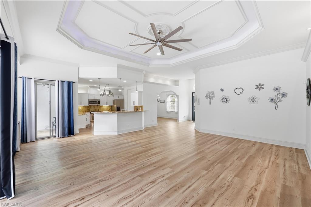 Spacious great room with a decorative tray ceiling, recessed lighting, and an open-concept layout.