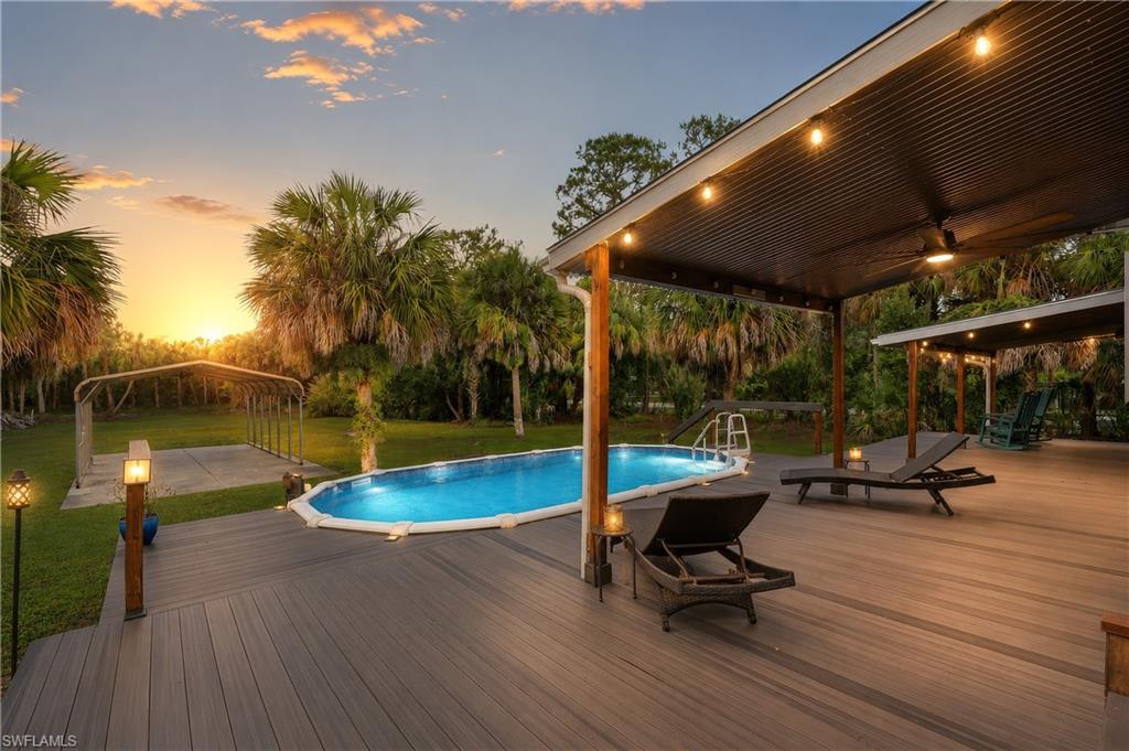 PVC deck surrounds the above-ground pool with expansive covered outdoor living areas for relaxing and entertaining.