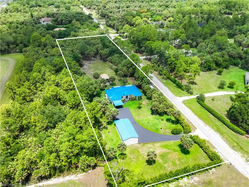 Aerial view outlines the 2.81-acre property with the home, detached garage, pool, and extensive grounds.