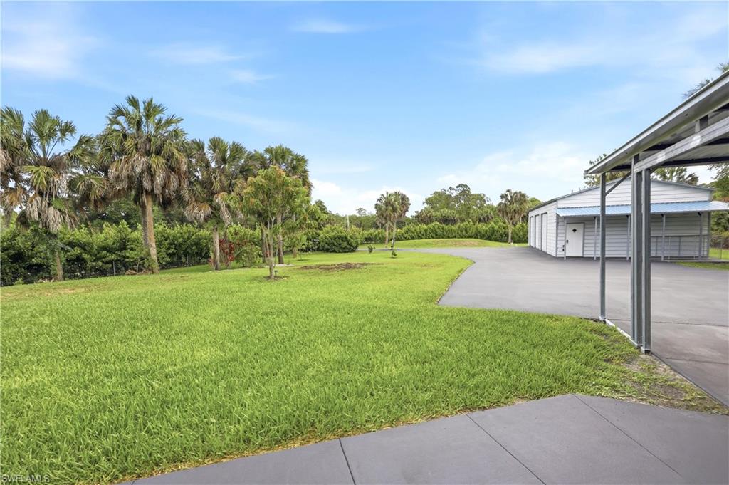 Open side yard provides additional outdoor space with convenient access to the detached garage and carport.