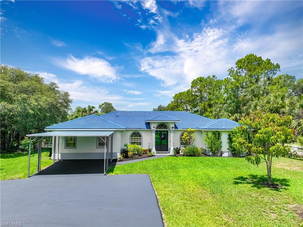 Attractive front elevation features a covered entry, metal roof, and manicured landscaping.