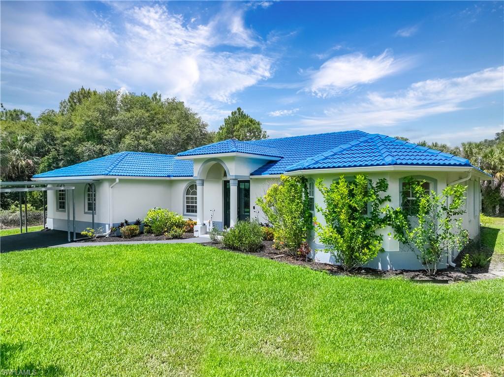Front exterior showcases a metal roof, mature landscaping, and a welcoming covered entry.