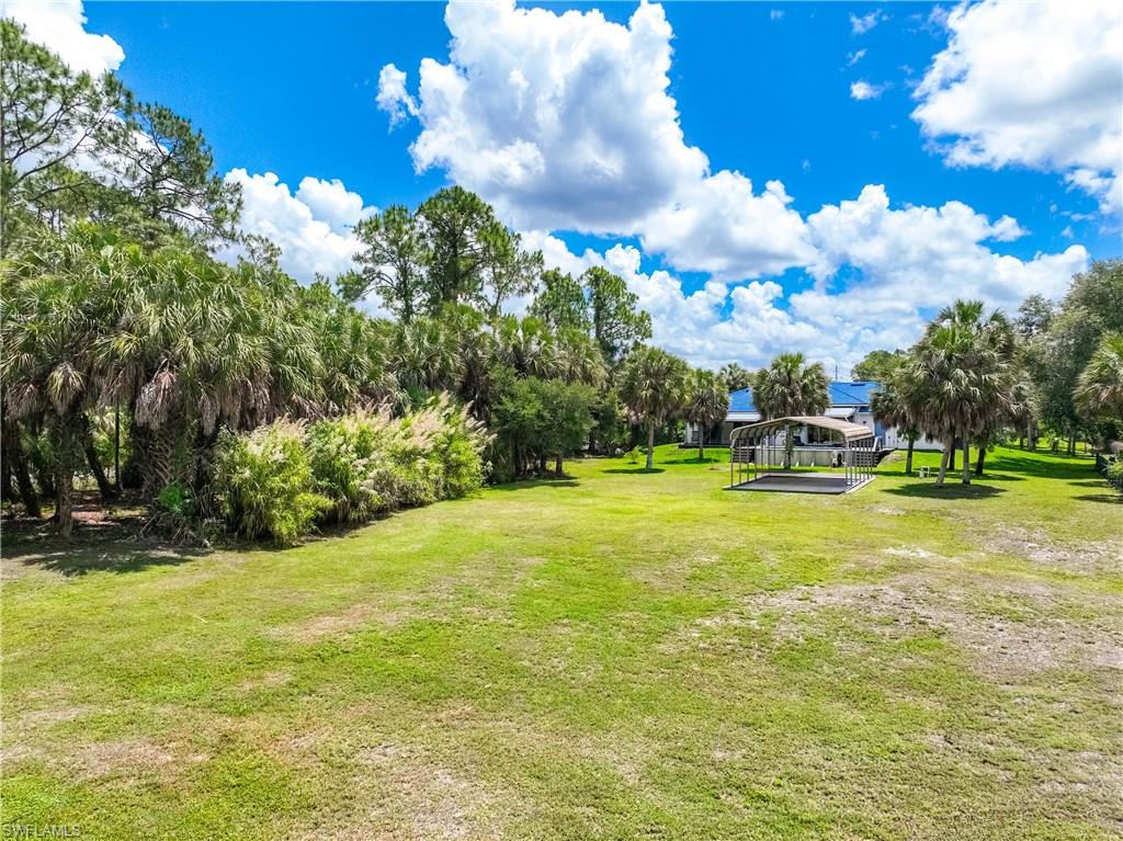Expansive backyard provides open green space, mature trees, and room to enjoy the 2.81-acre Golden Gate Estates property.