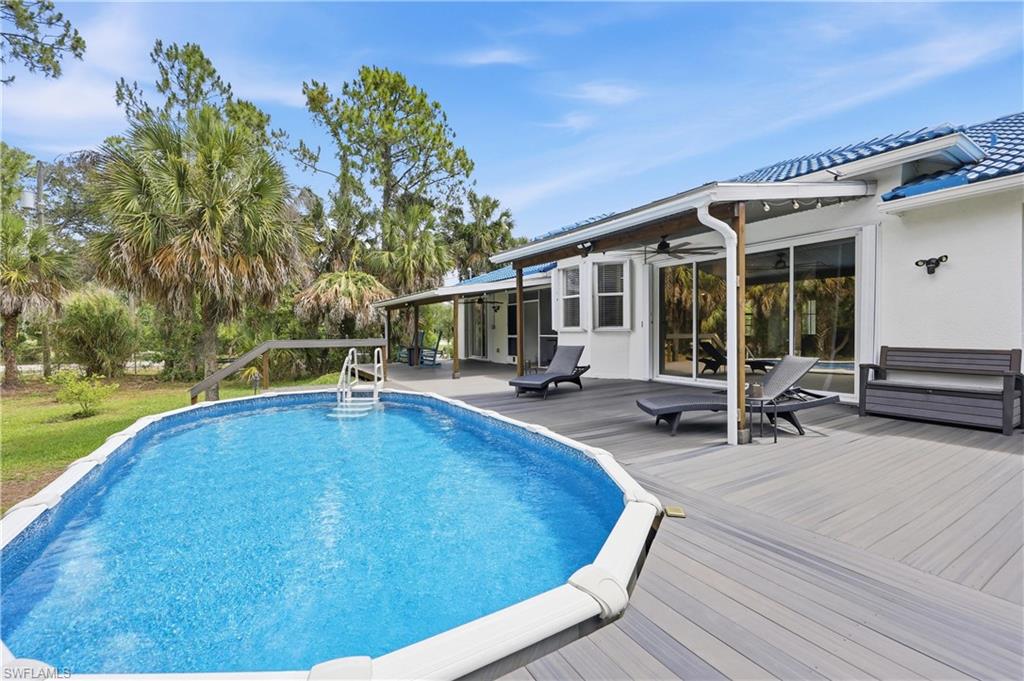 Above-ground pool is complemented by a spacious PVC deck and multiple covered seating areas overlooking the backyard.
