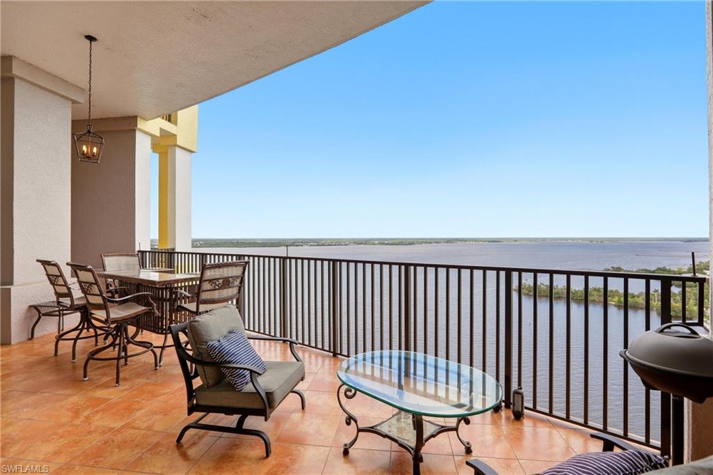 Balcony featuring outdoor dining space and a water view