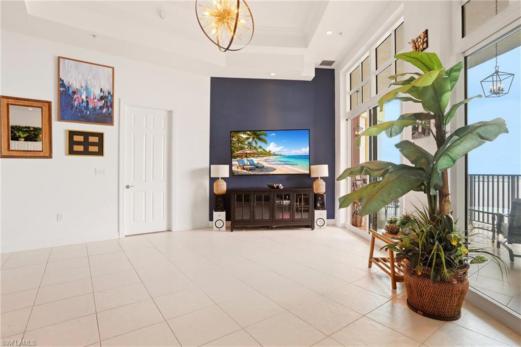 Tiled living area with a chandelier and a raised ceiling