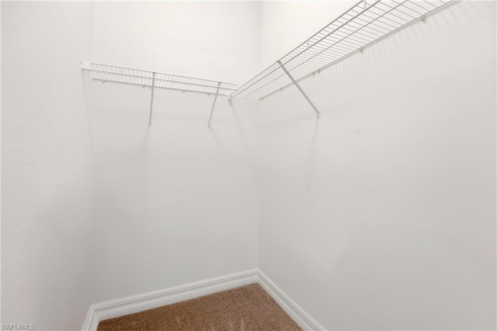 Walk in closet featuring light carpet