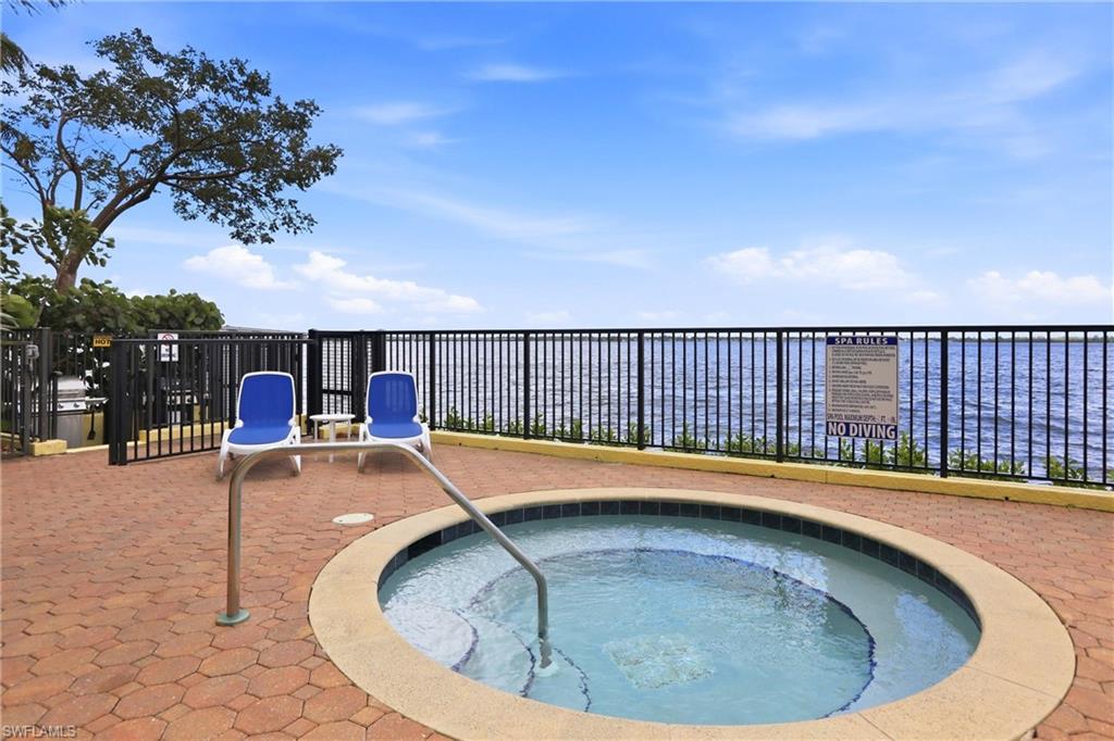 View of swimming pool featuring a hot tub and patio surround