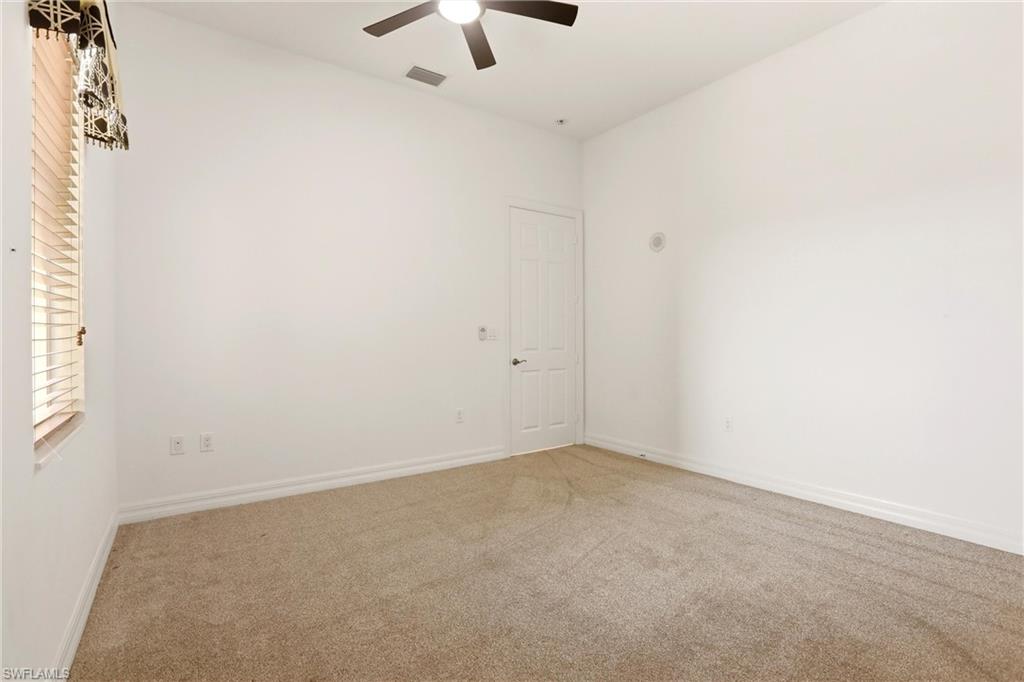 Carpeted empty room featuring baseboards and a ceiling fan