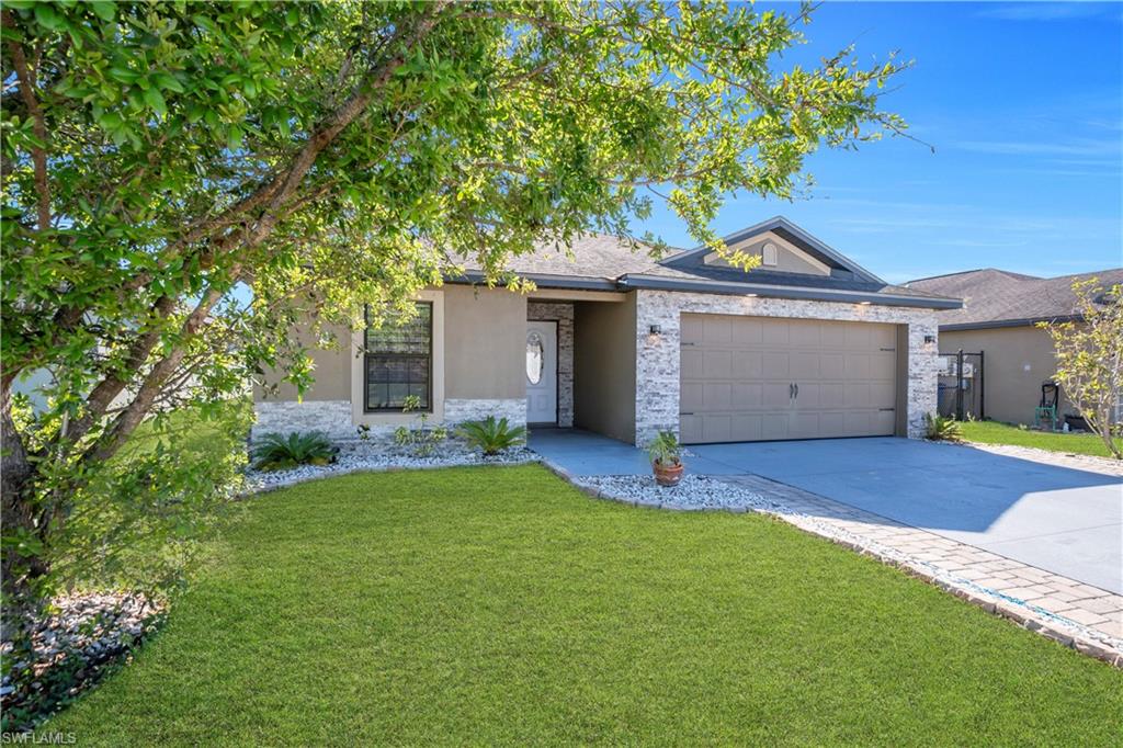 Ranch-style home featuring stone siding, driveway, a front lawn, a garage, and stucco siding