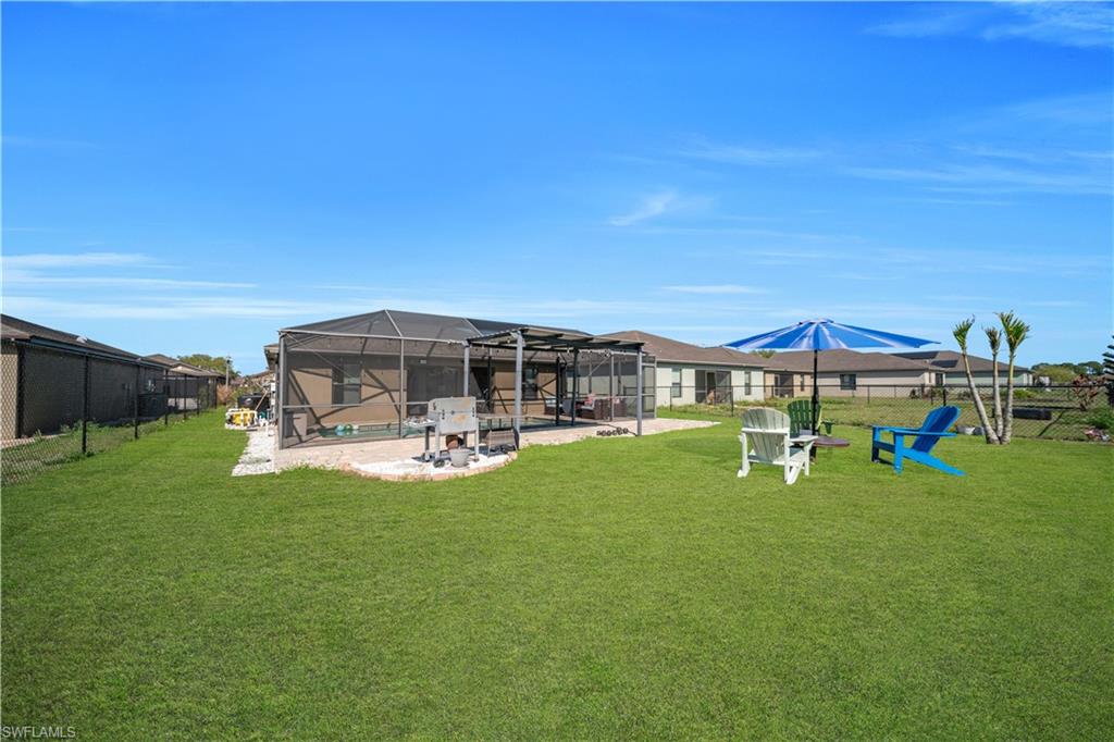Fenced backyard with a sunroom, a patio area, a swimming pool, and a lanai