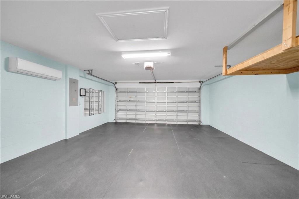 Garage featuring a wall mounted mini split and electric panel