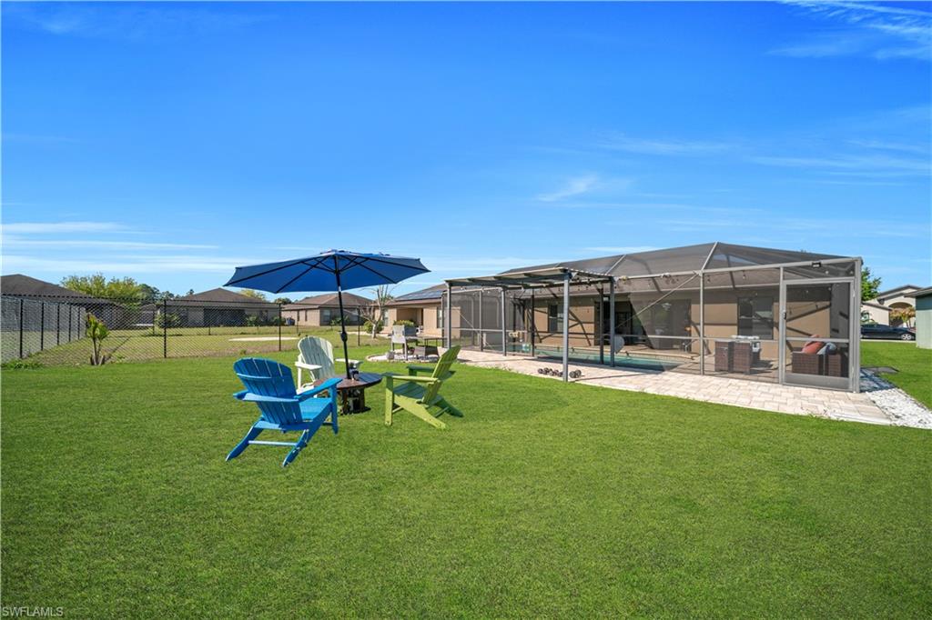 View of yard with a sunroom, a patio, and glass enclosure