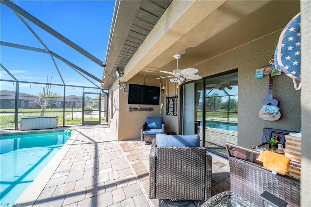 View of patio featuring an outdoor pool, a sunroom, a lanai, and a ceiling fan