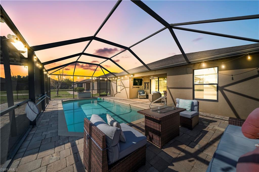 Outdoor pool featuring an outdoor living space, a sunroom, a patio, and a lanai