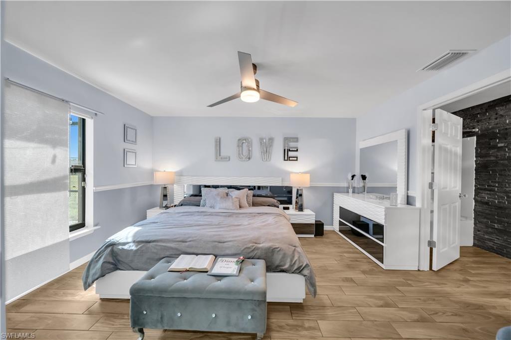Bedroom with wood tiled floors and a ceiling fan